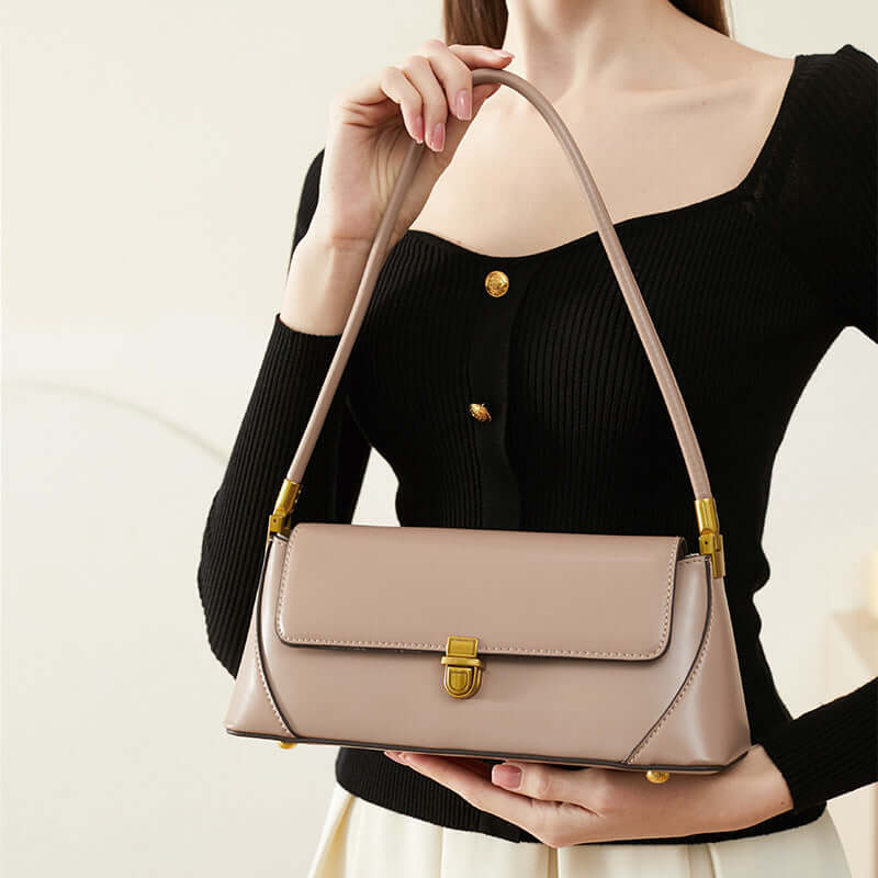 Small French baguette bag in brown leather carried by a woman, showcasing elegant design and versatile style